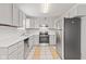 Well-lit kitchen featuring white cabinets, stainless steel appliances, and light tile flooring at 6227 Long River Ln, Indianapolis, IN 46221