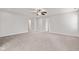Spacious carpeted living room with white walls and ceilings, ceiling fan, and multiple doorways at 6227 Long River Ln, Indianapolis, IN 46221
