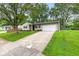 Inviting single-story house with a long driveway, attached garage, and lovely landscaping at 6310 Kellum Dr, Indianapolis, IN 46221