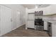 Well-lit kitchen boasts stainless appliances, granite countertops, white cabinets, and new wood-look floors at 6310 Kellum Dr, Indianapolis, IN 46221