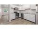 Modern kitchen with white cabinets, stainless steel appliances, granite countertops and wood look flooring at 6310 Kellum Dr, Indianapolis, IN 46221