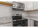 Stainless steel stove and granite countertops complement the white cabinets in this kitchen at 6310 Kellum Dr, Indianapolis, IN 46221
