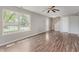 Bright living room with hardwood floors, a ceiling fan, and large windows offering ample sunlight at 6320 River Valley Way, Indianapolis, IN 46221