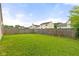 Wide backyard view featuring lush green grass, a wooden fence, and other neighborhood homes at 6332 Long River Ln, Indianapolis, IN 46221