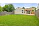 Large backyard featuring a patio, lush green grass, and a wooden fence, offering space and outdoor potential at 6332 Long River Ln, Indianapolis, IN 46221