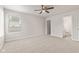 Bright bedroom features neutral carpet, a ceiling fan, and an ensuite bathroom with a large window at 6332 Long River Ln, Indianapolis, IN 46221