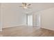 Spacious bedroom with ceiling fan, sliding glass doors, and modern wood-look flooring at 6332 Long River Ln, Indianapolis, IN 46221