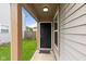 Exterior entrance featuring a black front door, covered porch, and manicured lawn at 6332 Long River Ln, Indianapolis, IN 46221