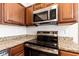 Modern stainless steel microwave and oven against a granite countertop with wooden cabinets at 6332 Long River Ln, Indianapolis, IN 46221