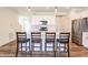 Open kitchen boasts bar stool seating at the island, stainless appliances, and bright, modern finishes at 640 Axford Bay Dr, Westfield, IN 46074