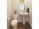 Charming powder room featuring a pedestal sink, wood flooring, and stylish decor for a sophisticated touch at 640 Axford Bay Dr, Westfield, IN 46074
