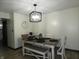A dining room features modern light fixture, table setting and bench at 6714 Colleens Way, Indianapolis, IN 46221