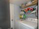 Functional laundry room featuring a white washer and dryer with ample shelving for storage at 6714 Colleens Way, Indianapolis, IN 46221