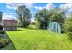 Large backyard with a quaint storage shed and a covered pergola with seating at 6842 Sextant Dr, Indianapolis, IN 46260