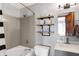 Neutral toned bathroom with a shower/tub, floating shelves, and an open door for enhanced natural light at 6842 Sextant Dr, Indianapolis, IN 46260