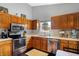 Well-equipped kitchen featuring wood cabinets, stainless appliances, and natural light from the window at 6842 Sextant Dr, Indianapolis, IN 46260