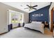 Inviting bedroom featuring a blue accent wall, large window, and comfortable sleeping area at 6842 Sextant Dr, Indianapolis, IN 46260