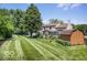 Spacious, well-manicured backyard featuring a sunroom, deck, shed, and mature trees, perfect for outdoor activities at 7211 Topp Creek Ct, Indianapolis, IN 46214