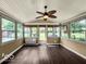 Bright sunroom surrounded by multiple windows, wood flooring and fan, offering a serene view of the backyard at 7211 Topp Creek Ct, Indianapolis, IN 46214