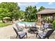 Inviting backyard with a pool, fire pit area, outdoor kitchen, and lush greenery, perfect for entertaining guests at 7220 Normandy Way, Indianapolis, IN 46278