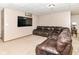 Cozy basement entertainment area featuring a large leather sectional sofa and a mounted flat screen TV at 7220 Normandy Way, Indianapolis, IN 46278
