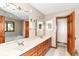 Well-lit bathroom with double sinks, wood cabinetry, and a large mirror at 7220 Normandy Way, Indianapolis, IN 46278