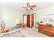 A bedroom is carpeted and has a ceiling fan, dresser, and closet space with a window view at 7220 Normandy Way, Indianapolis, IN 46278