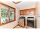 Convenient laundry room featuring modern washer and dryer with a pool view at 7220 Normandy Way, Indianapolis, IN 46278