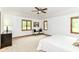 The primary bedroom is a carpeted room featuring a ceiling fan and three windows for natural light at 7220 Normandy Way, Indianapolis, IN 46278