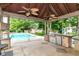 Outdoor kitchen and covered patio area overlooking the refreshing in-ground pool and well-maintained backyard at 7220 Normandy Way, Indianapolis, IN 46278
