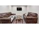 Basement living area features leather couches, area rug and adjacent TV area at 749 Bracknell Dr, Avon, IN 46123