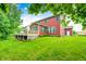 Back of the house with a large grassy backyard and deck surrounded by trees at 749 Bracknell Dr, Avon, IN 46123