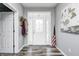 Bright foyer with hardwood floors, a decorative front door with sidelights and transom, and gray painted walls at 749 Bracknell Dr, Avon, IN 46123