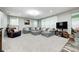 Spacious living room featuring plush gray sectional sofa, large windows, and neutral carpet at 749 Bracknell Dr, Avon, IN 46123