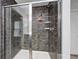 This shower is equipped with a glass door, dark tile, and convenient shelving at 749 Bracknell Dr, Avon, IN 46123