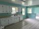 Kitchen with white cabinets, tiled flooring, and view into a room beyond a partial wall at 8045 Briarwood Dr, Indianapolis, IN 46227