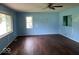 Living room featuring hardwood floors, two windows, and a ceiling fan at 8045 Briarwood Dr, Indianapolis, IN 46227