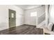 Bright entryway with dark wood floors, a modern door, and a staircase with black metal railings at 805 N Temple Ave, Indianapolis, IN 46201