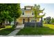 Inviting yellow two-story home with a classic design, showcasing a lush green lawn and mature trees at 805 N Temple Ave, Indianapolis, IN 46201