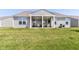Large green lawn leads to a covered patio area with dining and relaxing areas, all on a gray house at 8263 Bryce Blvd, Pendleton, IN 46064