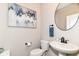 Stylish powder room features a pedestal sink, round mirror and artwork at 8263 Bryce Blvd, Pendleton, IN 46064