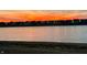 Tranquil view of homes near a pond at sunset, with vibrant colors and reflections on the calm water at 8263 Bryce Blvd, Pendleton, IN 46064