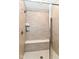 Modern shower stall with horizontal beige tile, a built-in bench, and glass door at 8263 Bryce Blvd, Pendleton, IN 46064