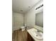 Clean bathroom with white fixtures, updated lighting and wood look flooring at 832 Spinney Ln, Whiteland, IN 46184