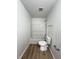 Bathroom featuring a white shower-tub combo with an updated toilet and laminate flooring at 832 Spinney Ln, Whiteland, IN 46184
