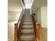 Staircase with decorative wood and iron banister, neutral carpeting and wood look floors at 832 Spinney Ln, Whiteland, IN 46184