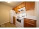 A functional kitchen featuring white appliances, wood cabinets, and wood-look floors at 8410 Hague Rd # 5, Indianapolis, IN 46256