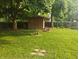 Green backyard with mature trees, wooden shed, and privacy fence at , Carmel, IN 46280