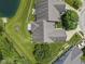 Aerial view of the house showing a backyard with mature trees, a small patio, and direct pond access at 10934 Harness Ct, Indianapolis, IN 46239
