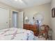 Bedroom features a light quilt, wooden dresser and chair, and neutral carpet at 10934 Harness Ct, Indianapolis, IN 46239